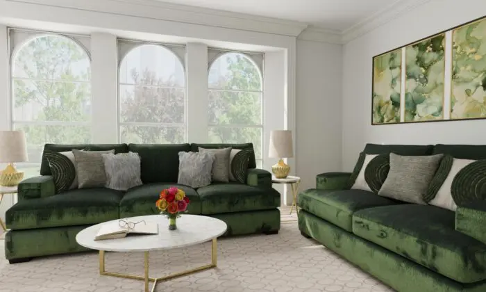 Green velvet sofa and loveseat set with gold accents in a modern living room