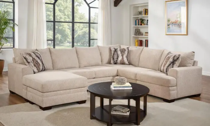 Wayne Sand 2 Piece Sectional with Chaise in a living room with large windows.