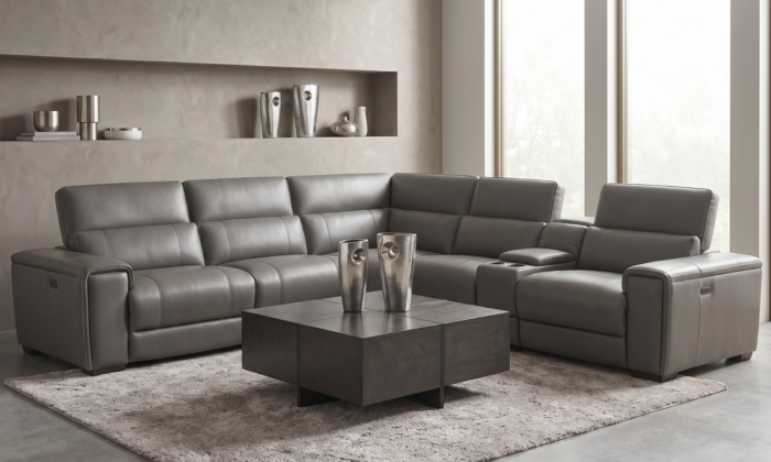 Crestview Luxe Grey Leather Reclining Sectional arranged in a modern living room next to a dark wood square coffee table.