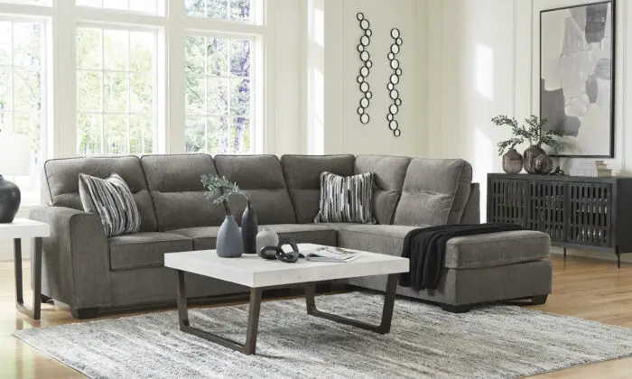 Benchcraft Olten Graphite 2-Piece Sectional with Chaise featuring plush charcoal gray upholstery, deep chaise lounge, and patterned throw pillows